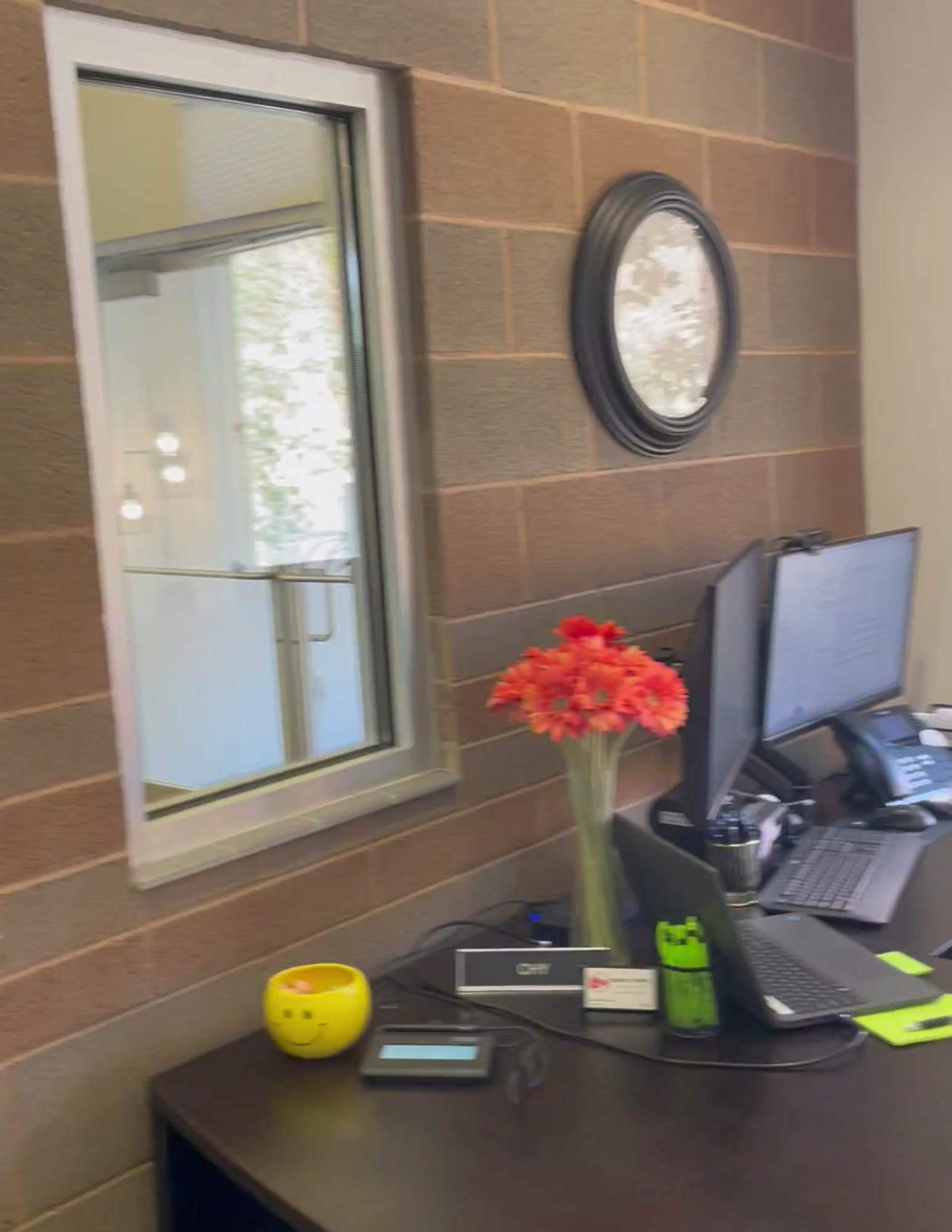 Remodeled office with window, paneling and red flowers.