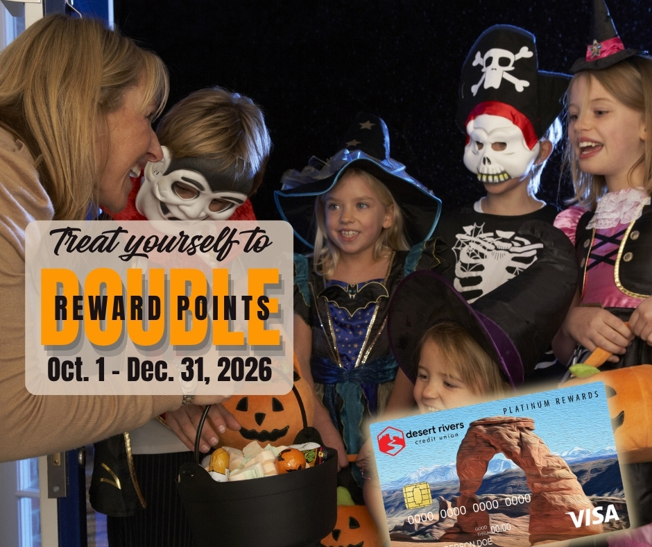 Neighbor lady handing out Halloween candy to a group of children in costumes treating herself to double reward points on every purchase she makes with her Desert Rivers Credit Union VISA credit card through December 31st.